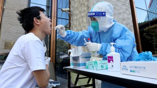 一名医务工作者从一名男子身上采集拭子样本以检测Covid-19冠状病毒