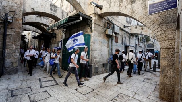يهود يحملون العلم الإسرائيلي وهم يسيرون في أحد أزقة القدس القديمة.