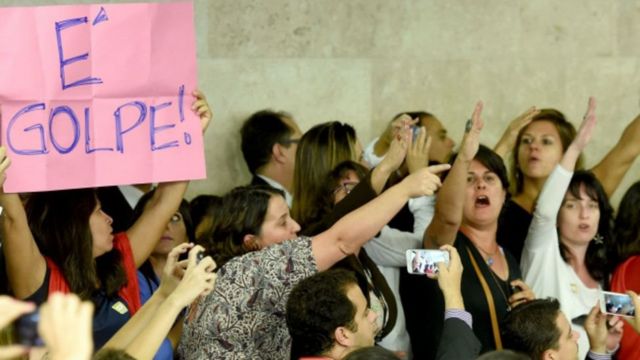 Público con carteles de "Es golpe" en el Congreso