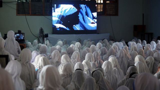 Freiras indianas da organização de Madre Teresa assistem a sua canonização pela TV