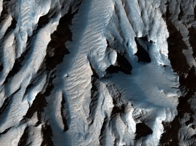 ส่วนหนึ่งของหุบผาที่เรียกว่า Tithonium Chasma เต็มไปด้วยรอยเส้นทแยง ซึ่งแสดงถึงวงจรที่น้ำแข็งตัวและละลายตัวนับครั้งไม่ถ้วนในอดีต