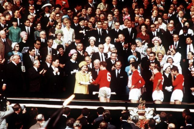 El capitán de Inglaterra, Bobby Moore, sostiene el Trofeo Jules Rimet, recogido de manos de la reina, después de llevar a su equipo a una victoria por 4-2 sobre Alemania Occidental en la final de la Copa del Mundo en Wembley, Londres.