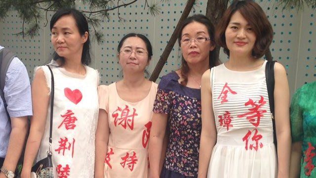 Some of the wives of the lawyers and activists, with messages of support stuck on their dresses