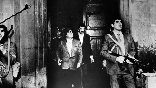 Salvador Allende, con casco y un arma, frente al palacio de la moneda, 11 de septiembre de 1973