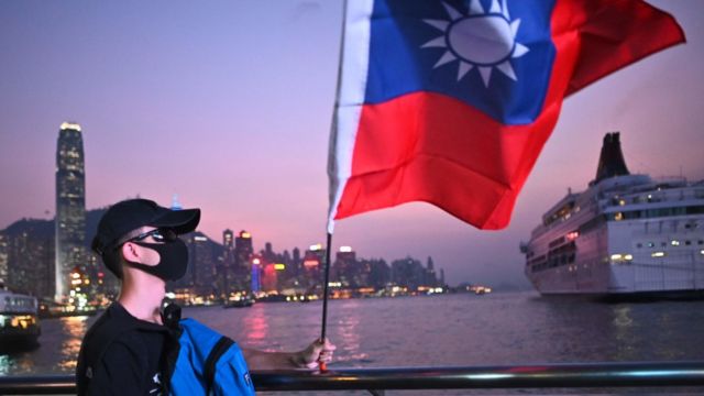 香港尖沙咀海旁一名戴著口罩的「反送中」示威者高舉台灣青天白日滿地紅旗幟(10/10/2019)