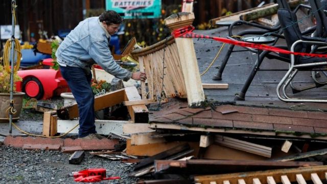 A man inspects an earthquake-damaged building.