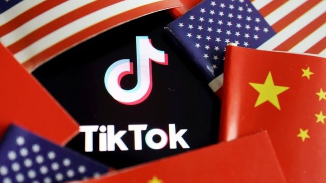 The flags of China and the US are seen near a TikTok logo