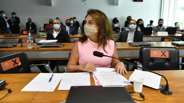 Kátia Abreu sentada diante de mesa de comissão, com máscara