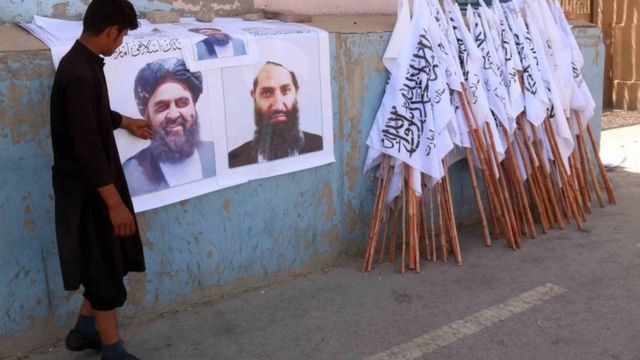 Плакаты с лидерами талибов и их флагом на улице Кабула