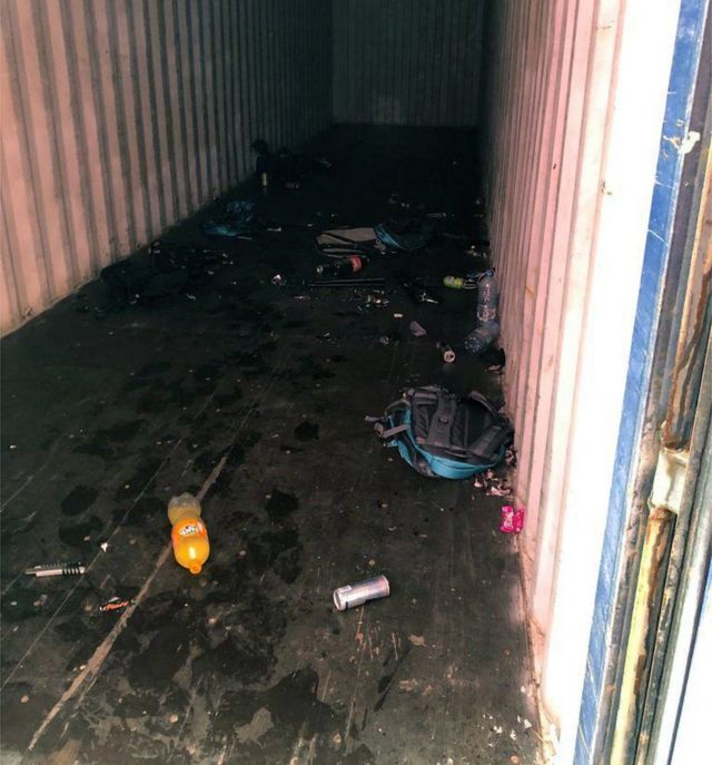 Un contenedor vacío con botellas vacías y otros restos de la presencia de los recolectores.