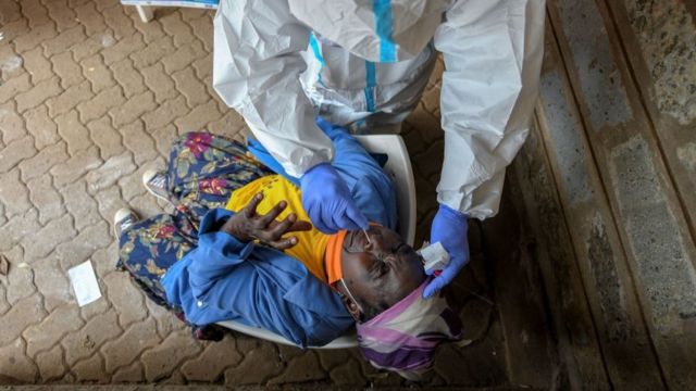Une femme âgée réagit à un test nasal lors d'un test de masse pour le coronavirus COVID-19 à Nairobi au Kenya