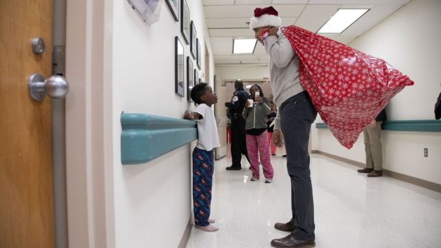 Keçmiş ABŞ prezidenti Barack Obama uşaq tibbi mərkəzində Santa Claus papağında uşaqlara hədiyyə paylayır və onların valideynlərini salamlayır - Washington DC, 19 dekabr 2018
