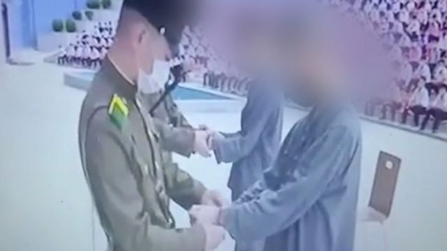 سرباز به دو نوجوان دستبند می‌زند