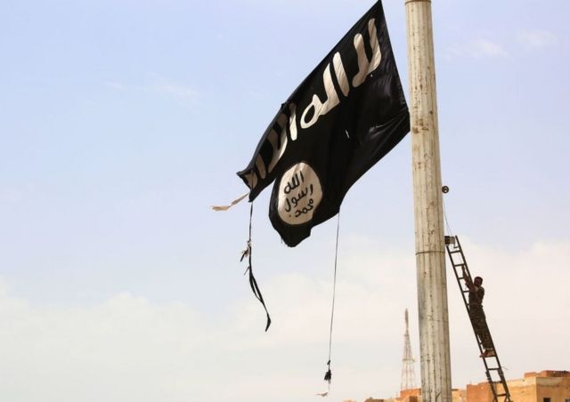 Član Sirijskih demokratskih snaga (SDS), koje podržavaju Sjedinjene Države, uklanja zastavu Islamske države u gradu Tabka 30. aprila, 2017.