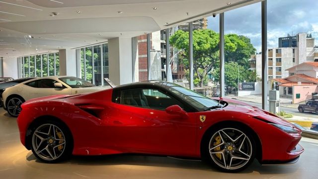 Fotografia mostra um carro Ferrari vermelho em uma loja