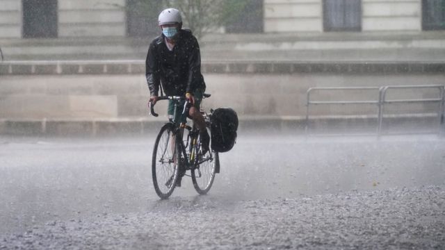 A cyclist wading through the water on Horse Guards Road in central London (7/25/2021)