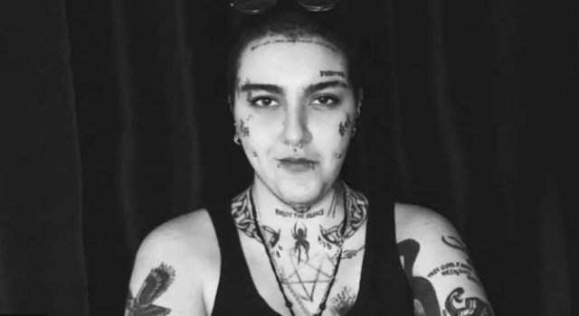 Mulher com tatuagens e piercings