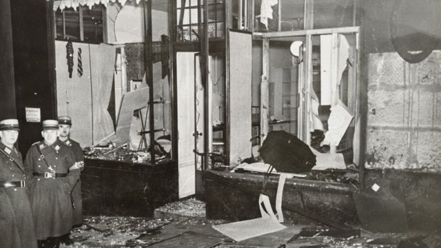 Oficiales nazis observan una tienda judía que ha sido atacada