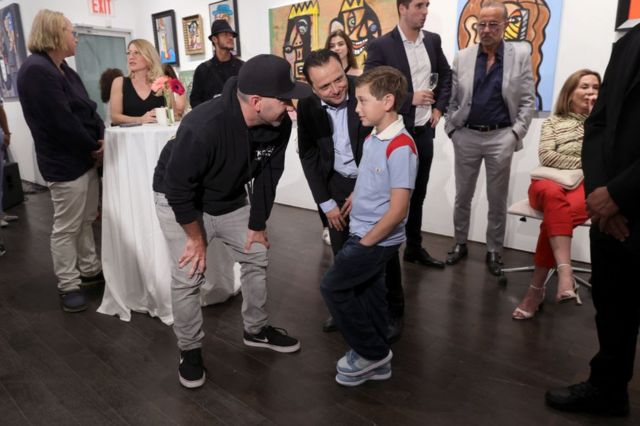 Andrés Valencia con su padre Guadalupe Valencia y Scott Budnick (con gorra negra) durante la inauguración de su primera exposición individual en la galería Chase Contemporary de Nueva York el 23 de junio de 2022.