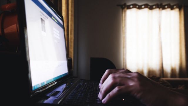 Homem acessando o Facebooj no computador
