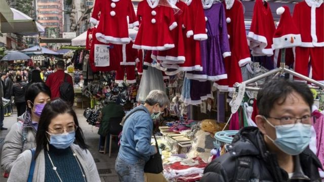 Pedestrians walk past a Christmas costume street shop in Hong Kong, China, 21 December 2020.