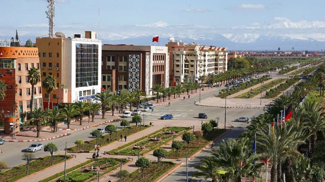 شارع محمد الخامس في مراكش، المغرب، مع المباني السكنية والبنوك والجبال البعيدة