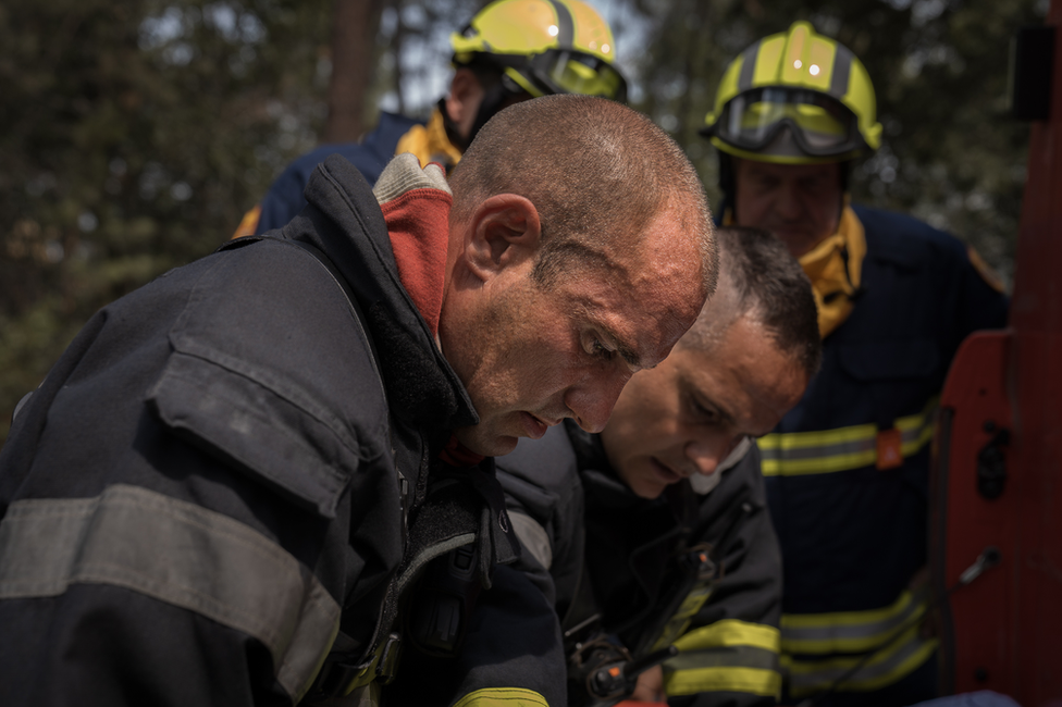 Los bomberos se ayudan de un mapa cerca del borde de los incendios forestales en Gironde.
