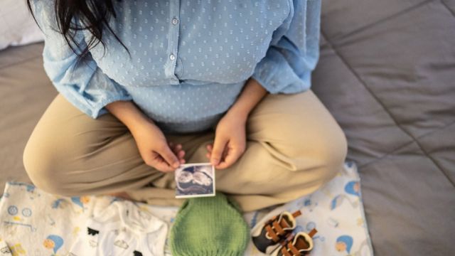 Una mujer embarazada viendo una imagen de su bebé.