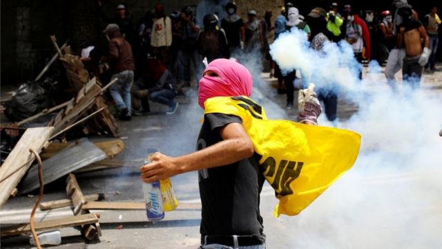 A demonstrator prepares to throw a tear gas canister during a strike called to protest against Venezuelan President Nicolas Maduro's government in Caracas, Venezuela on 26 July, 2017.