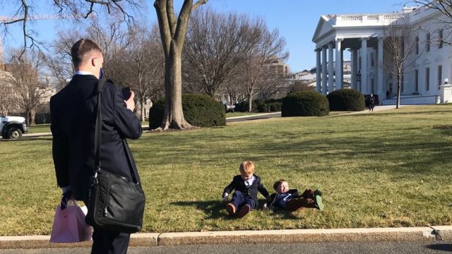 Man taking picture of children on White House lawn