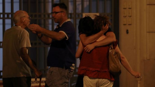 Unas personas se abrazan en una calle de Niza.