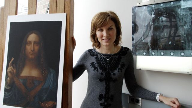 Fiona Bruce in conservation studio in New York with print of Salvator Mundi (newly discovered Leonardo da Vinci painting)