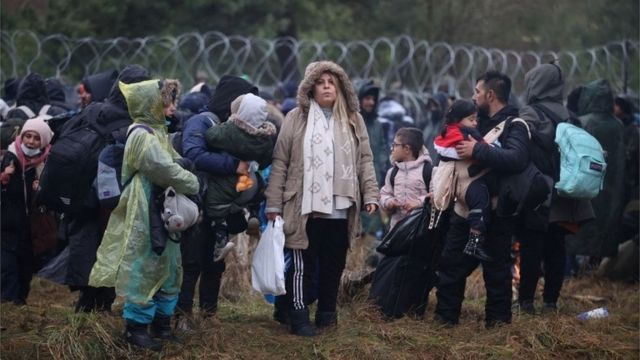 Migrants near a border fence on the border of Belarus and Poland