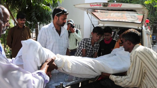 পাকিস্তানে মদ পানে মৃত একজনকে গাড়িতে উঠানো হচ্ছে