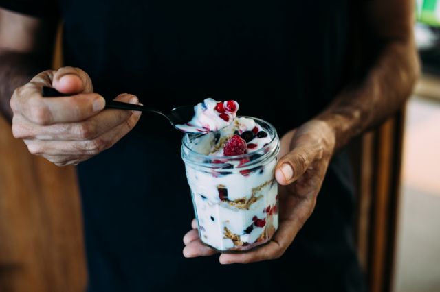 A man holds a jar of yogurt