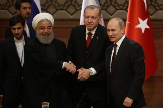 Three-way handshake between Iranian President Hassan Rouhani, on the left, Turkey's Erdogan, centre, and Russian President Vladimir Putin, right
