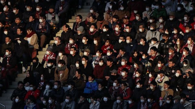 Torcedores de futebol no Japão assistem a uma partida entre Vissel Kobe e Yokohama F. Marinos