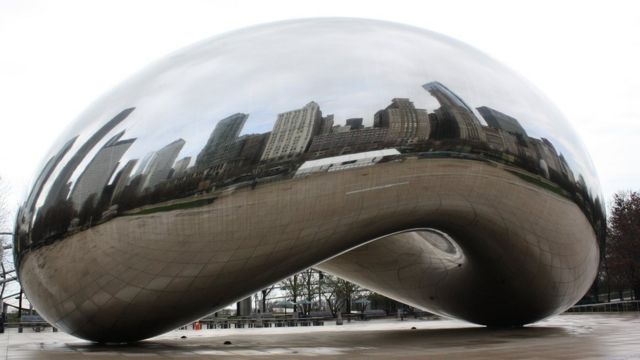 Reflejos de los edificios en una escultura de metal