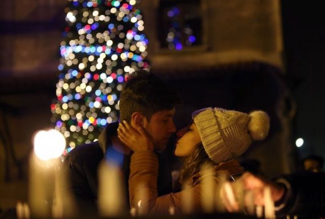 A couple kiss during a Christmas Eve ceremony at St Antuan Church in Istanbul, Turkey