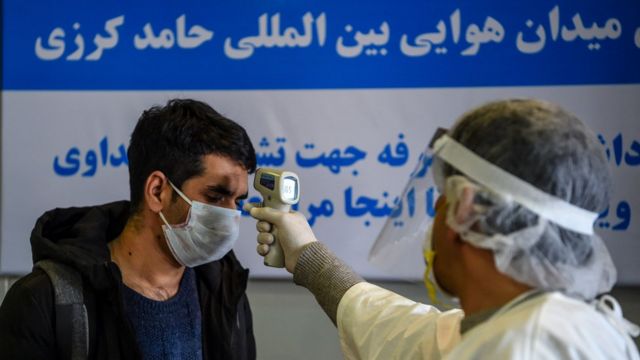 Boy in Afghanistan gets his temperature check