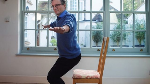 莫斯利医生亲自尝试坐下再站起，注意，要慢坐再正常站起就是一种有效的离心运动。(photo:BBC)