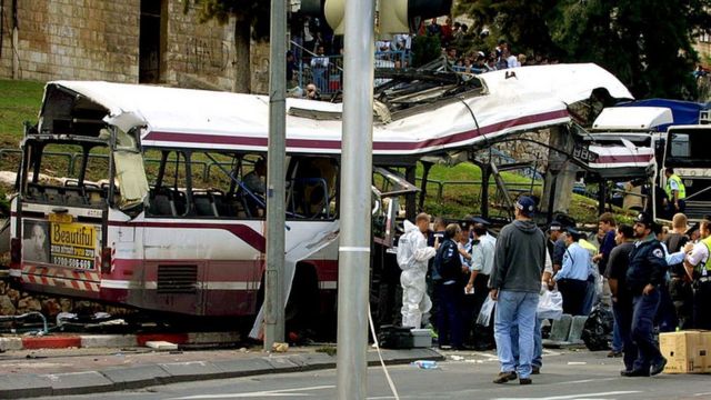 Autoridades israelíes investigan los restos de un autobús tras un ataque con bomba en Haifa, 2001