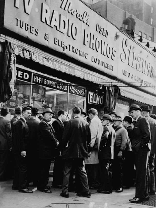 Una multitud congregada ante un comercio en Radio Row para escuchar las noticias sobre el asesinato del presidente John F. Kennedy.