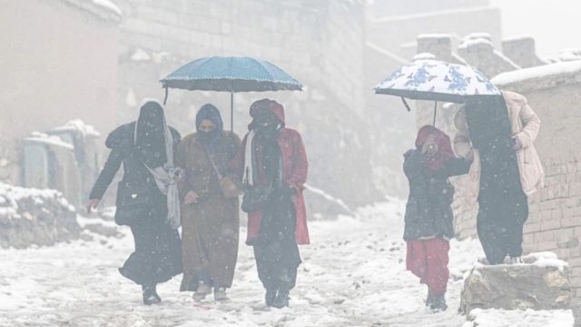 نساء أفغانيات تسرن في الثلوج