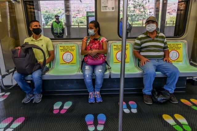 Tres personas en el transporte público en Medellín, Colombia.