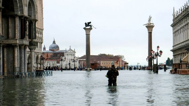 A man stands in water at the flooded St Mark's Square during exceptionally high water levels in Venice, Italy, 13 November 2019