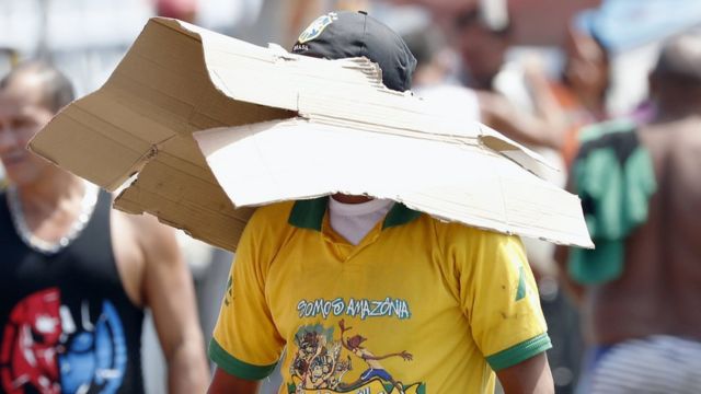 Hombre cubriéndose del sol con un cartón