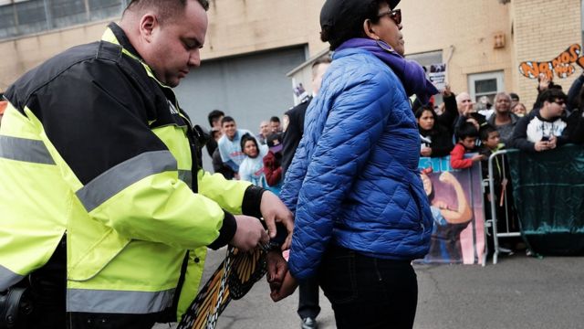Agente del Servicio de Inmigración y Control de Aduanas arresta a una mujer.