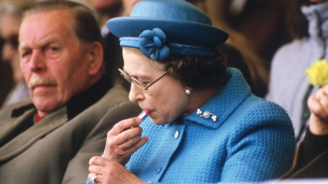 Королева подкрашивает губы в королевской ложе на скачках в Аскоте