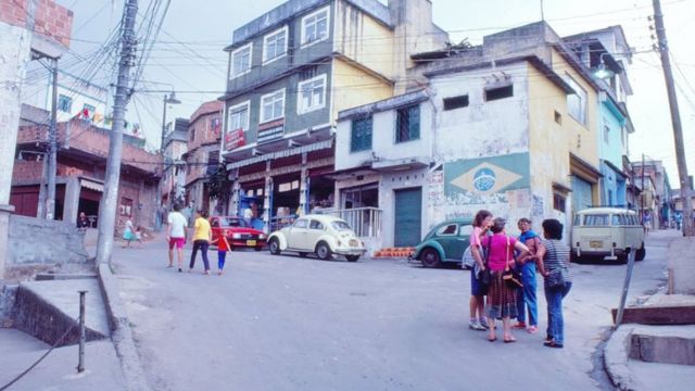 Mulheres conversam e moradores transitam na subida da favela do Jacarezinho